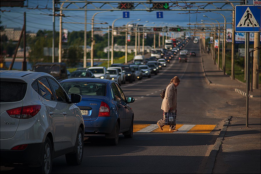 Бабушка переходит по пешеходному переходу на мосту в Костроме